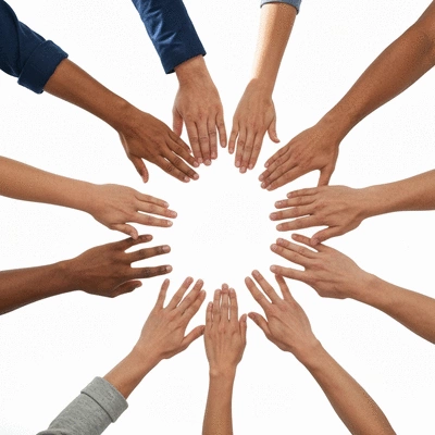 Hands of diverse people reaching in to form a circle, symbolizing community action and unity